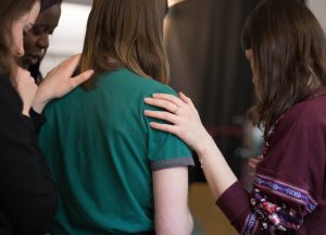 Une intervenante pose la main sur l'épaule d'une participante, en signe de soutien, dans le cadre du suivi communautaire